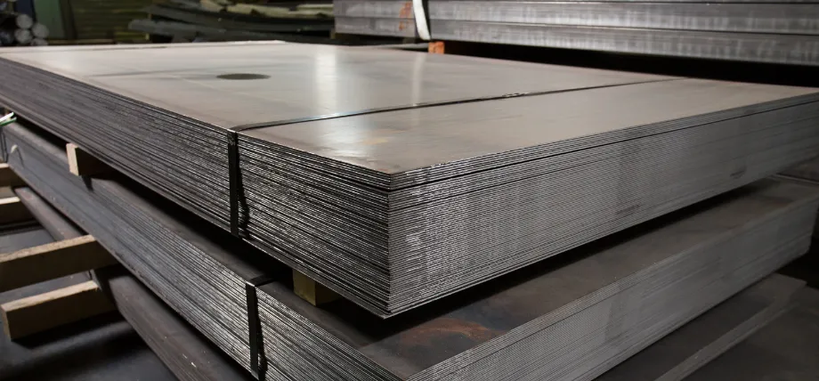 Multiple heavy-duty steel or aluminum sheets stacked neatly on wooden pallets in a warehouse setting.