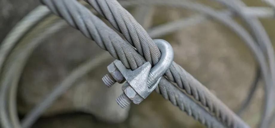 A heavy-duty steel wire rope secured with a galvanized U-bolt saddle clamp