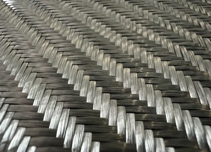 Close-up of woven carbon fiber fabric in a herringbone pattern