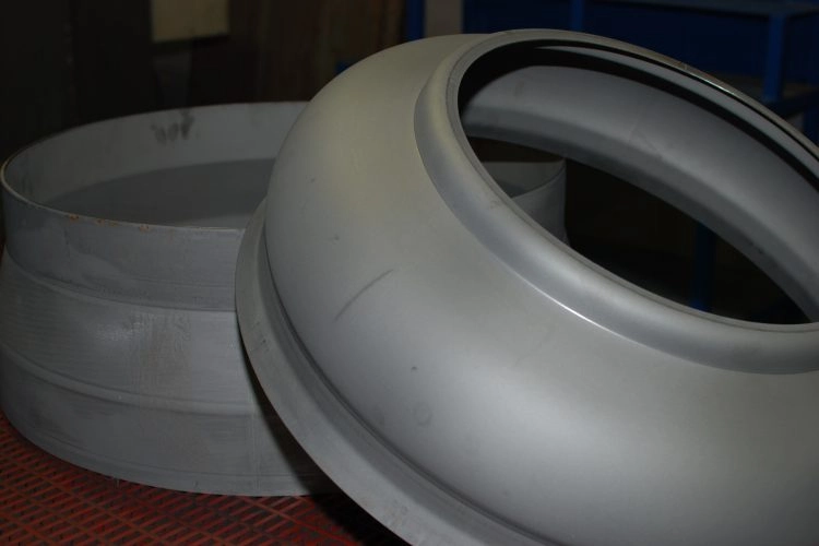 The image shows a sheet metal bulge forming where pressure is applied to create a raised and expanded section on the metal surface.