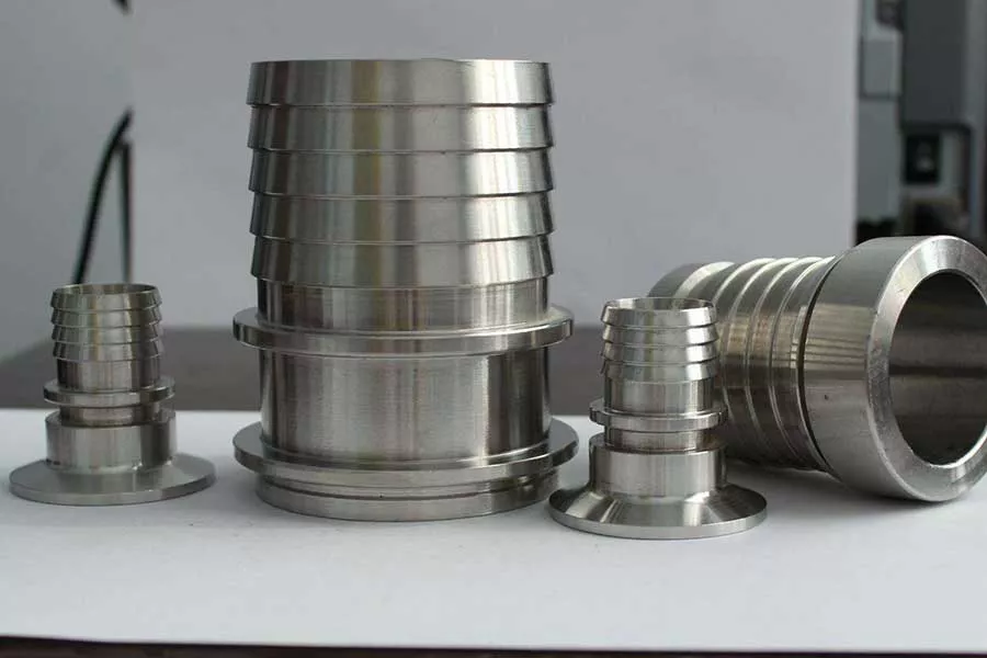 Stainless steel hose barb adapters in various sizes displayed on a table. 