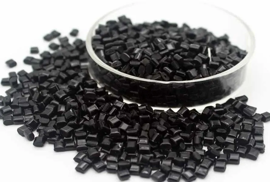 The image shows black glass-filled nylon pellets used as raw material for vacuum casting and injection molding.