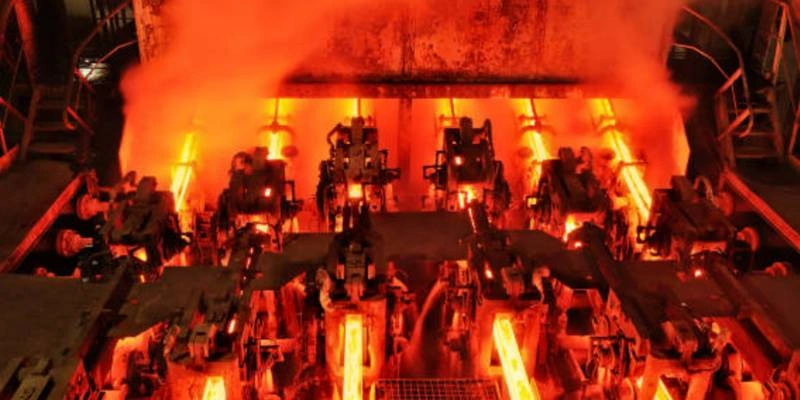 Red-hot steel bars moving through an industrial heat-treating production line