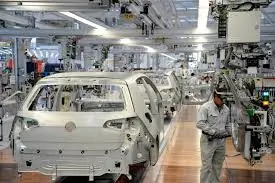 Car bodies are moving along an automated assembly line in a factory.