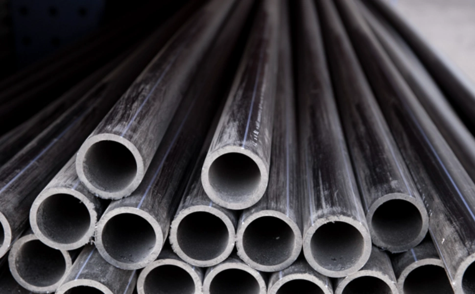 Dark grey PVC pipes stacked together, showing machined hollow circular cross-sections at the cut ends