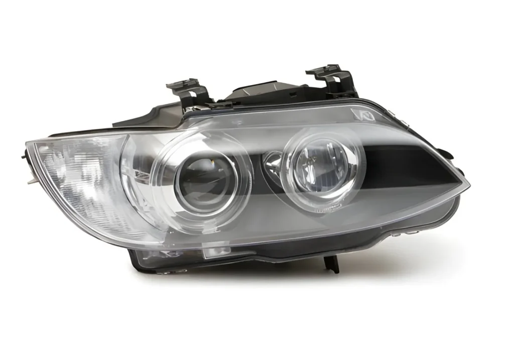 The image shows an automotive headlight made from polycarbonate, featuring a clear, durable lens with precise molding for optical performance.