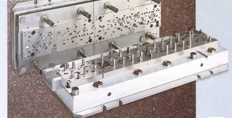 Metal progressive die tool with multiple stations and guide pins mounted on a base