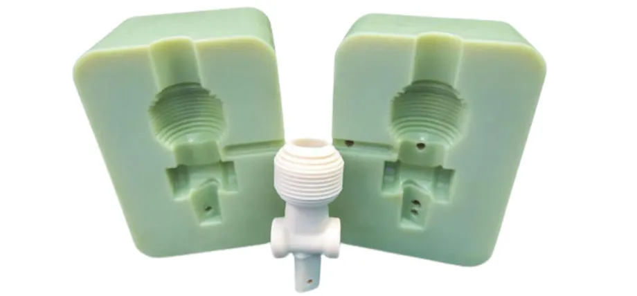 A light green two-part silicone or soft polyurethane mold separated to show the internal cavity next to a white threaded plastic prototype part.