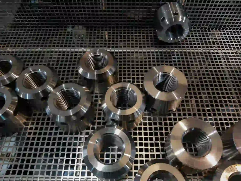 The image shows stainless steel engine components, including a machine valve, cylinder, and engine block.