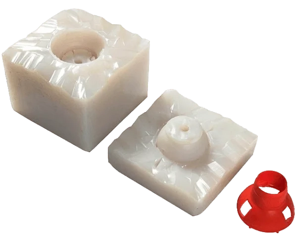 The image shows a red vacuum-cast part placed beside its master mold.