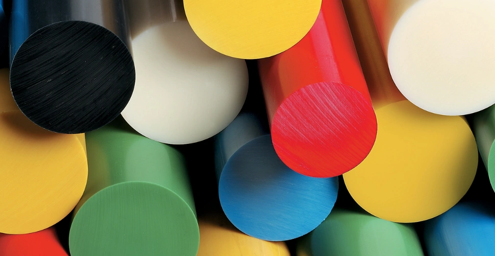 Stacked acetal copolymer rods in black, white, red, green, blue, and yellow.
