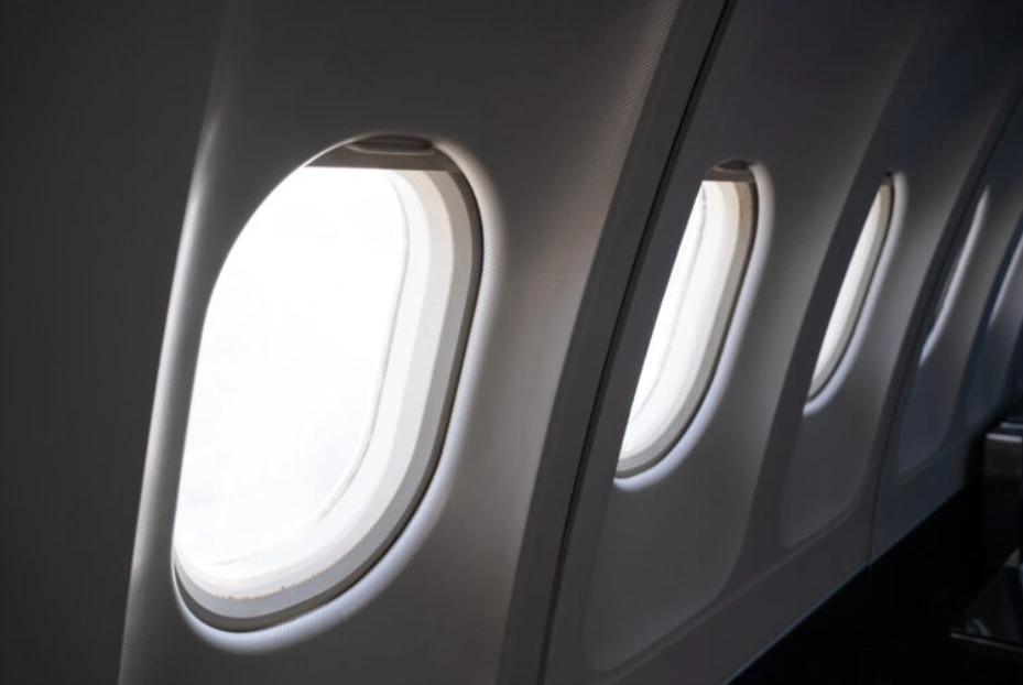 Aircraft-grade polycarbonate windows on a commercial airplane interior cabin wall.