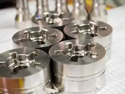 Close-up of shiny machined metal parts arranged on a technical drawing