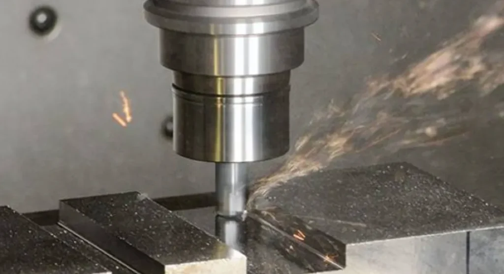 End mill cutting a slot into a metal workpiece with sparks and chips visible