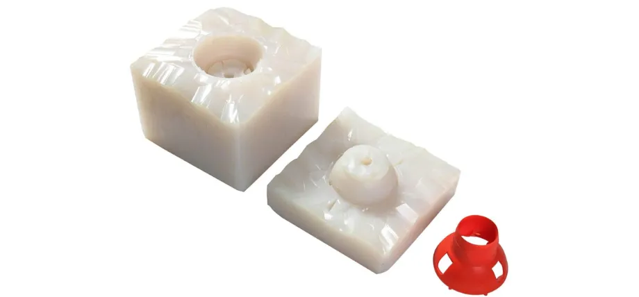 Two-part white silicone mold with a red plastic master pattern used for vacuum casting