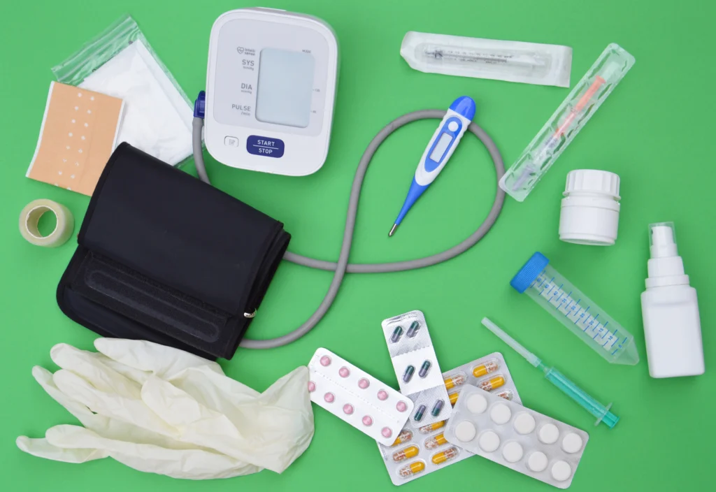 Common medical devices and supplies laid out on a green background