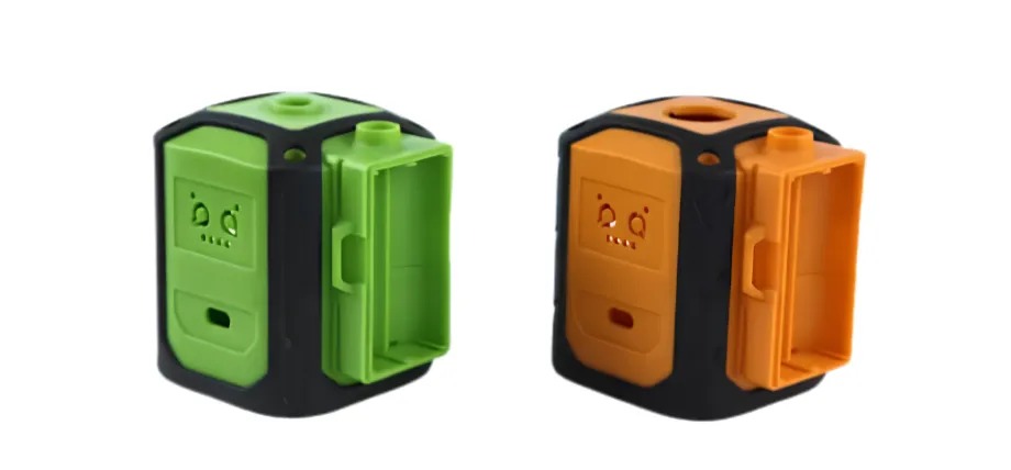 Two custom-molded plastic electronic housing enclosures, one green and one orange, featuring black overmolded protective borders.