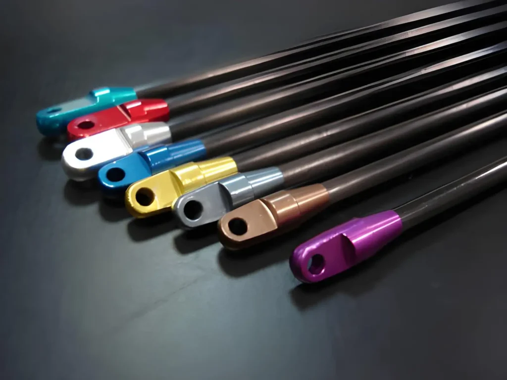 Anodized aluminum parts in different colors displayed on a black background