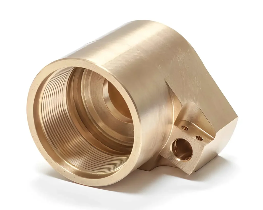 The image shows a CNC-machined brass component with visible internal threading. The cylindrical part has smooth, machined surfaces and precise, uniform threads inside the bore.