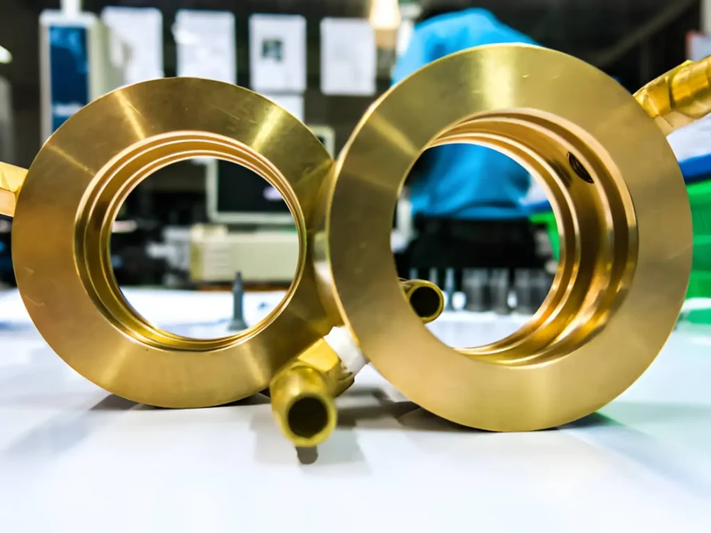Machined brass circular components for cooling water systems with a gold-colored finish