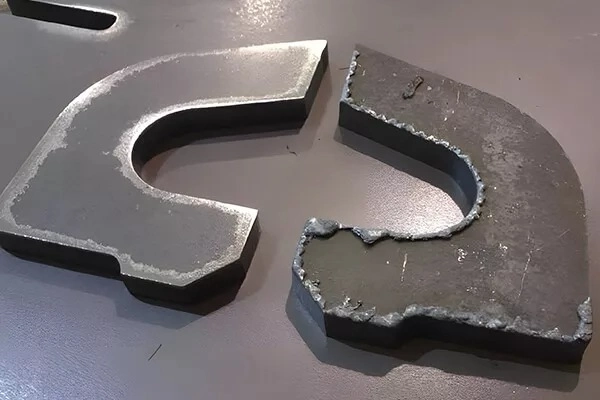 The image showing sheet metal parts showing burred and deburred edge comparison