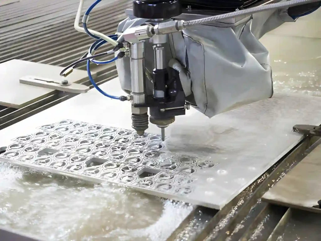 The image shows a CNC waterjet cutting process, where a high-pressure stream of water cuts metal. 