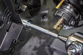 lose-up of a CNC lathe machining a metal shaft.
