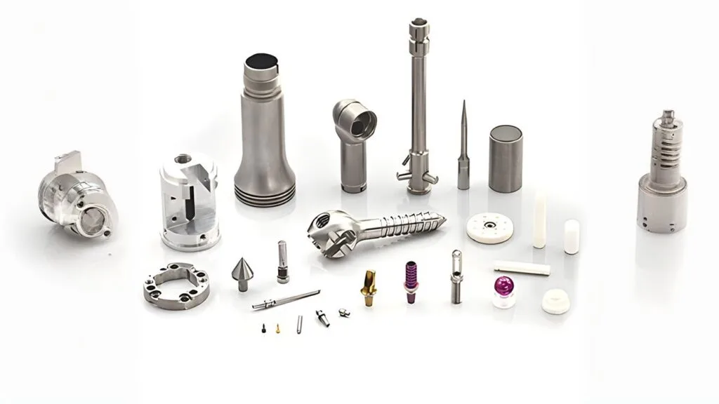 Assorted precision CNC-machined metal components on a white background.