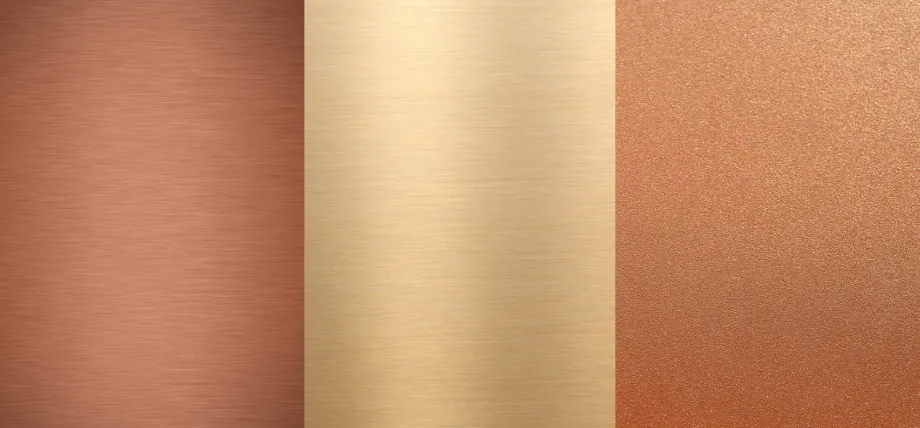 Three polished metal rods—brass, copper, and bronze—displayed with identifying labels to show differences in color and luster.