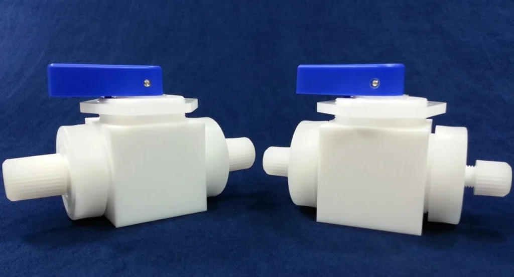 Two white machined PTFE ball valves with blue lever handles and threaded end fittings.