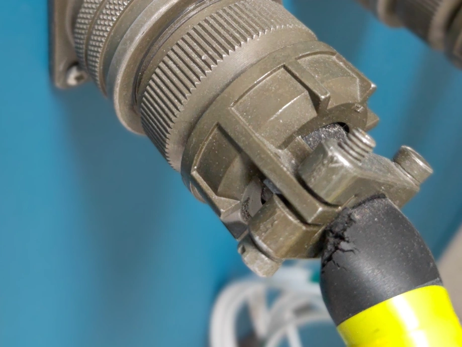 Close-up of an aerospace electrical connector with PTFE-machined components and insulated wiring