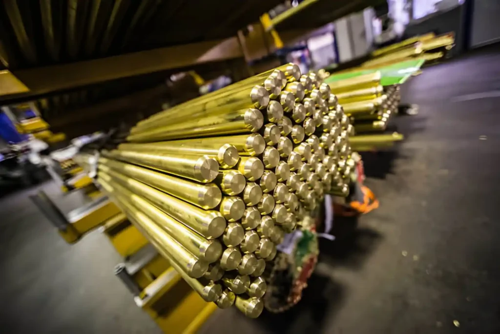 Raw brass pipes arranged in a factory setting.