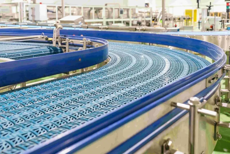 Blue UHMWPE modular conveyor belt on a curved food processing line