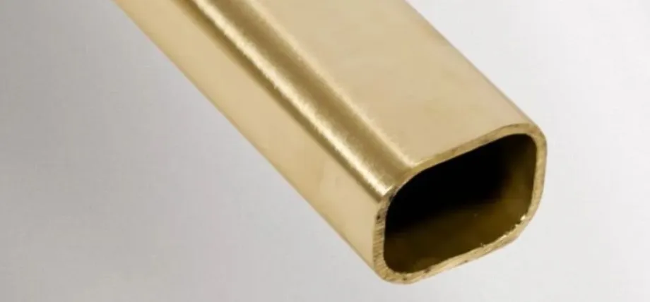 A close-up of a rectangular brass tube with a smooth, brushed gold surface and visible wall thickness at the cross-section.