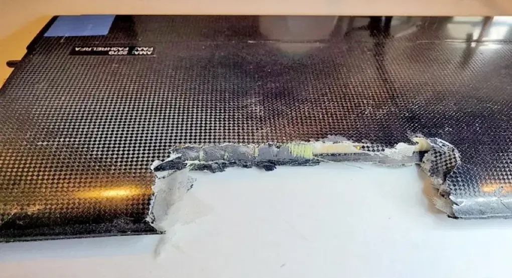 Carbon fiber laminate panel with impact-induced delamination and edge fracture