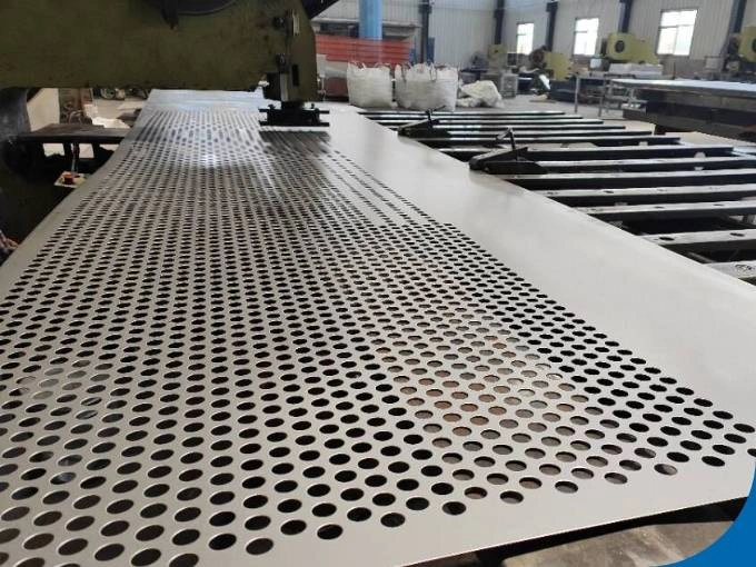 Worker feeding sheet metal into a yellow industrial punch press machine