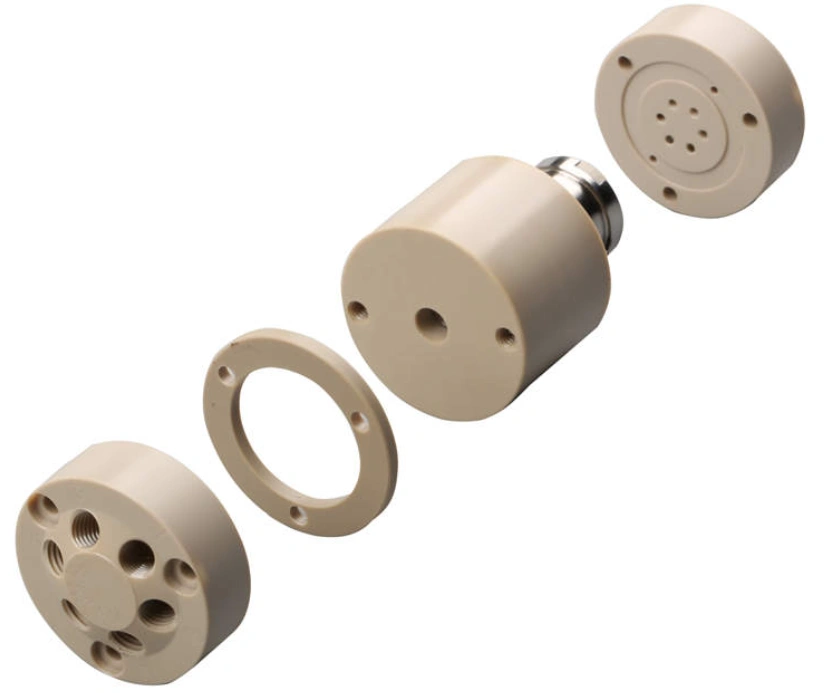 Exploded view of precision-machined PEEK cylindrical housing assembly with threaded and perforated components