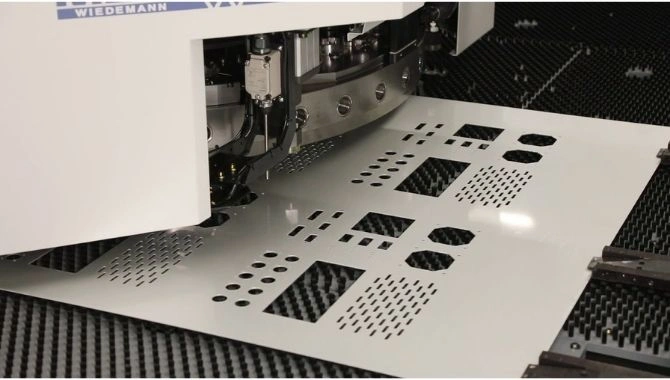 CNC punch press cutting various shaped holes in a white metal sheet