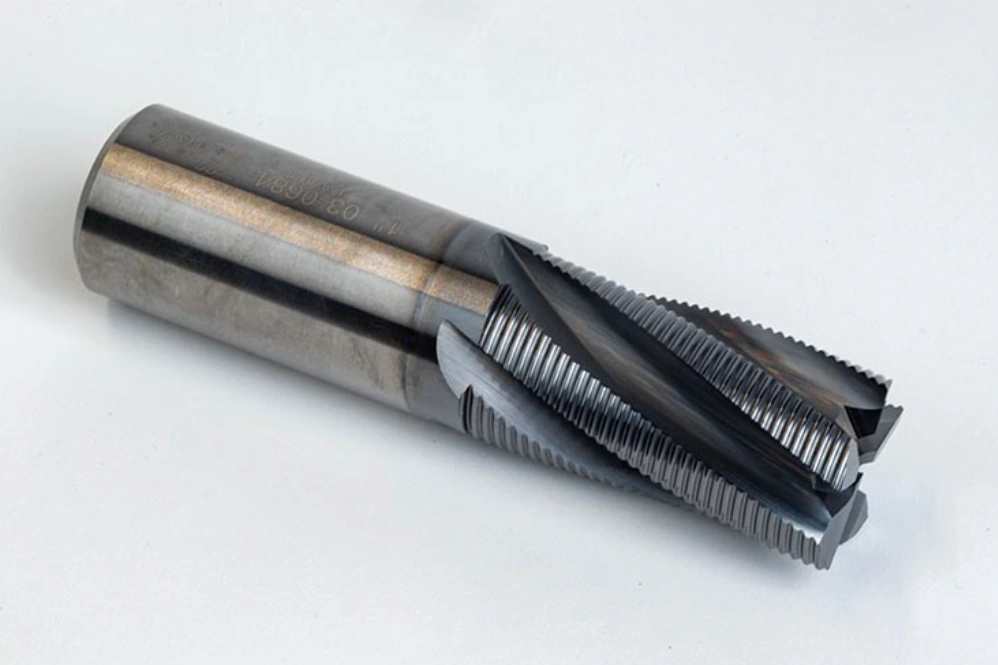 Carbide roughing end mill with serrated chip breaker flutes on a white background. 