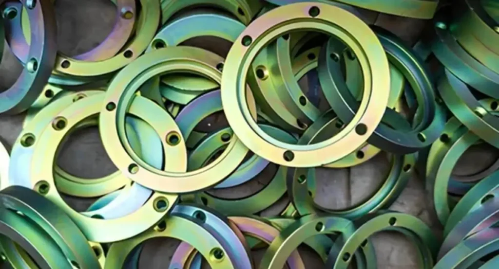 Pile of circular metal flanges with a green-gold zinc-nickel plating finish