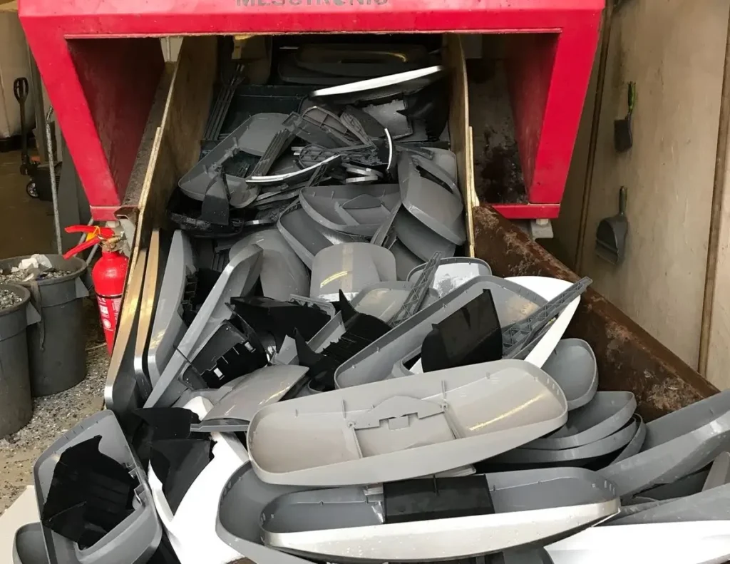 Bin of scrapped ABS plastic automotive parts collected for recycling  