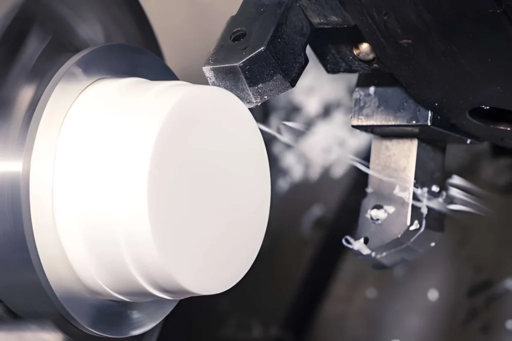 A round HDPE part being turned on a CNC lathe