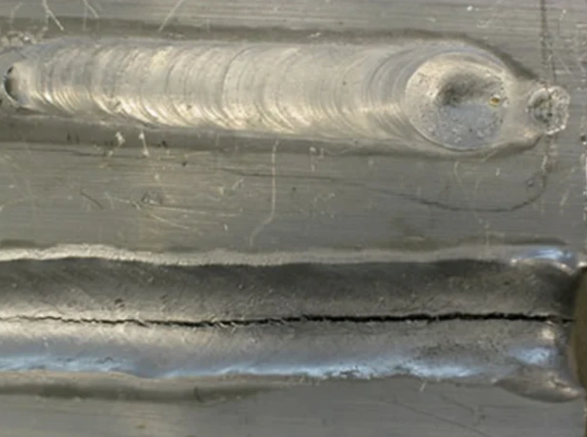 Aluminum weld beads on a metal surface, one showing centerline hot cracking
