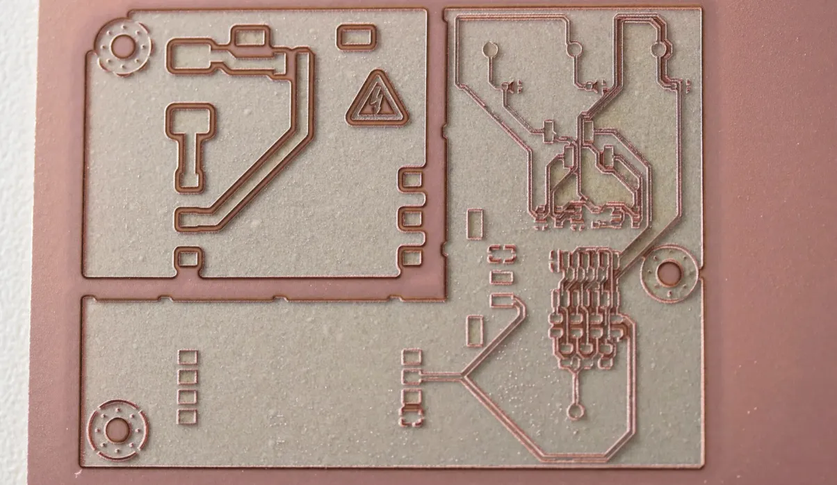 Laser-engraved copper PCB showing intricate circuit trace patterns and component outlines