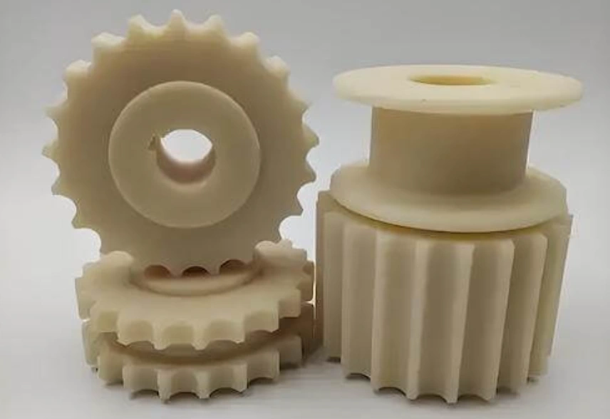 Cream-colored machined nylon gears and pulley components