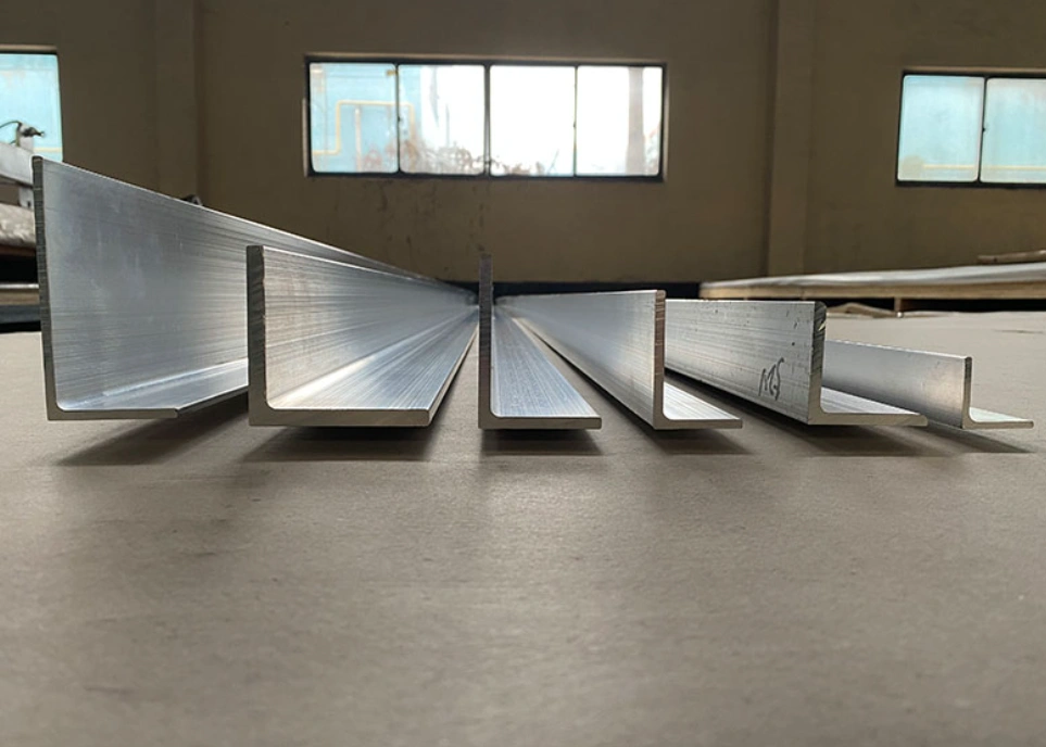 Row of L-shaped 6061 aluminum angle extrusions in varying sizes on a workshop floor