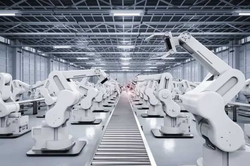 Rows of automated robotic arms along a conveyor line in a mass-production facility.