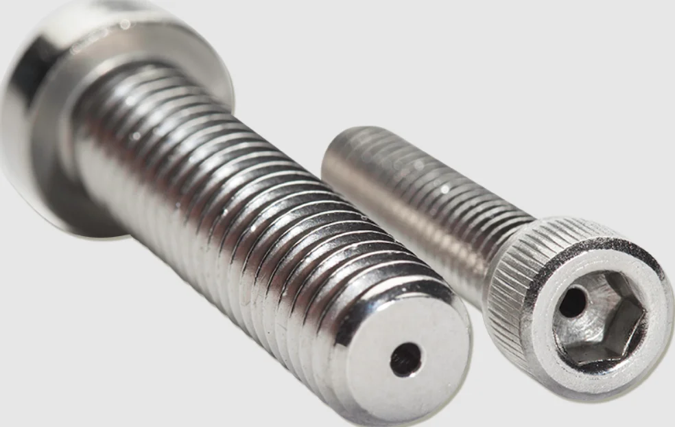 Two shiny electropolished stainless steel socket head cap screws with hex drive.