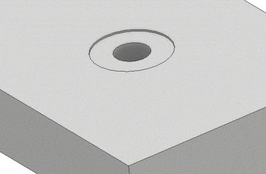 Gray CAD model of a flat block with a spotface hole showing a very shallow circular recess around a through hole
